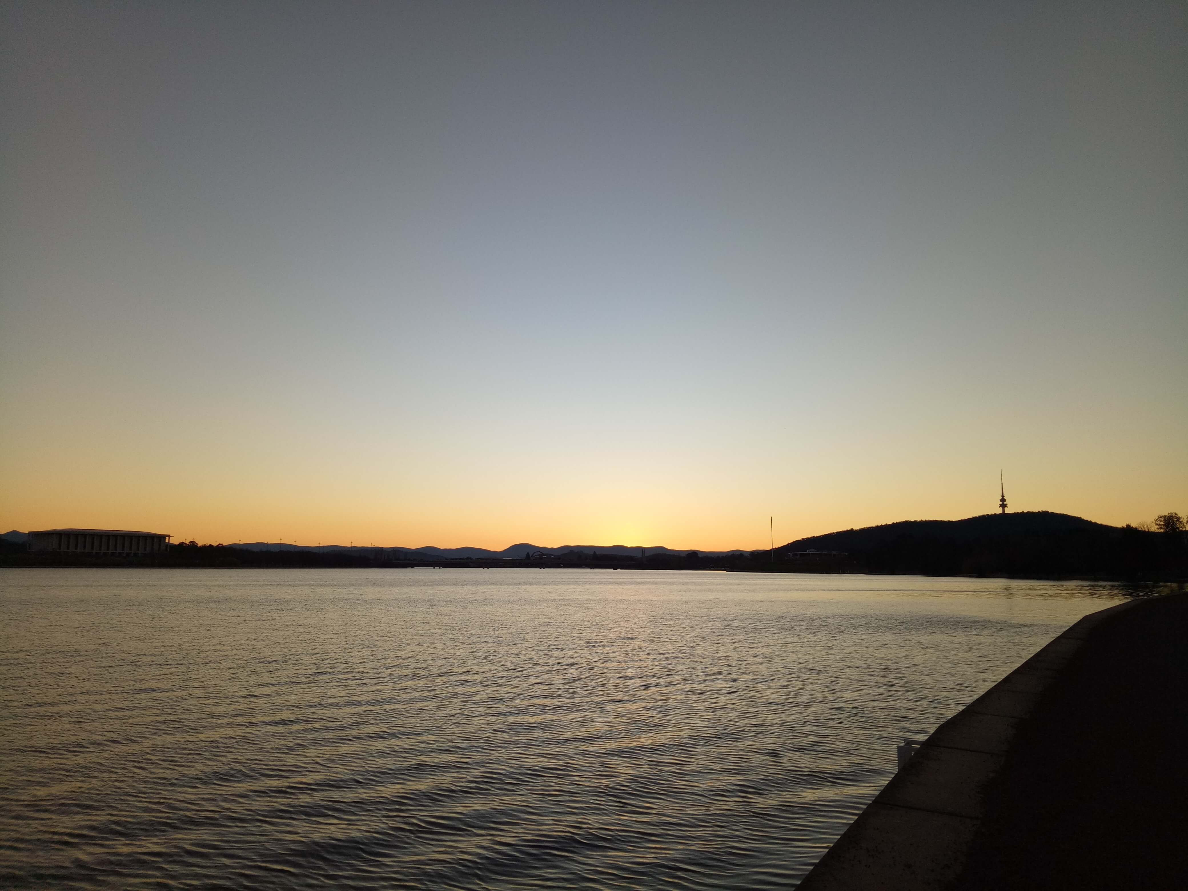 A photo of Lake Burley-Griffin at sunset, with Telstra tower visible in silhouette